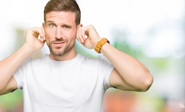 Hombre Guapo Vistiendo Casual Camiseta Blanca Cubriendo Las Orejas Con — Foto de Stock