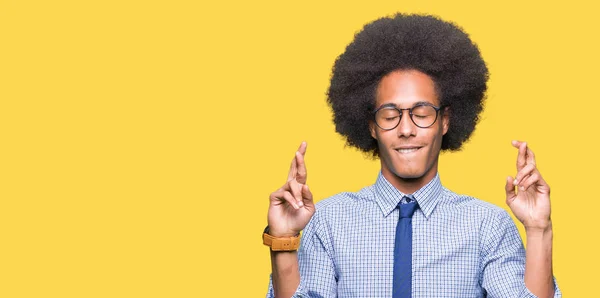 アフロ髪眼鏡笑顔希望と目を閉じて交差指若いアフリカ系アメリカ人ビジネスマン運と迷信的な概念 — ストック写真