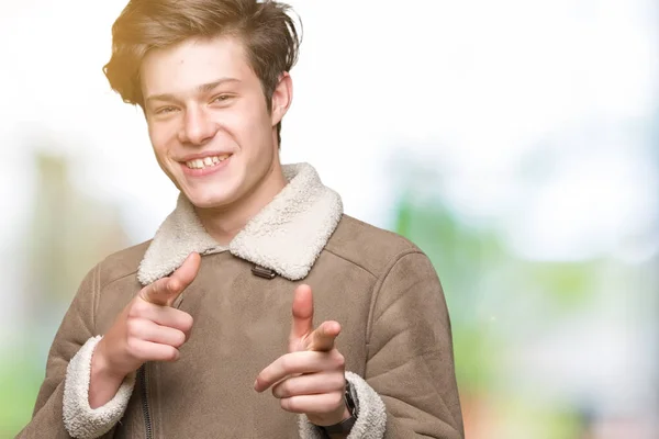 上冬のコートを着ている若いハンサムな男は 幸せと面白い顔でカメラに指を指して背景を隔離しました 良いエネルギーとヴァイブス — ストック写真