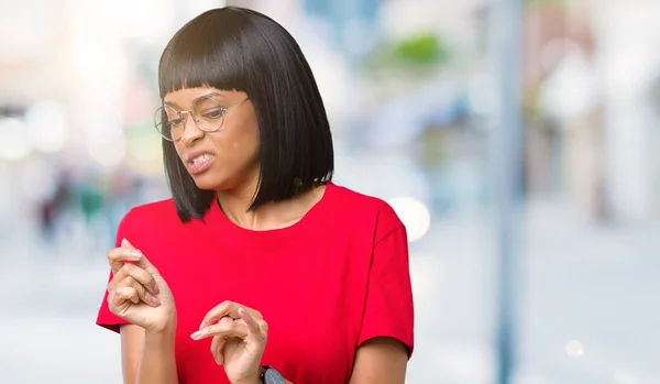 Beautiful young african american woman wearing glasses over isolated background disgusted expression, displeased and fearful doing disgust face because aversion reaction. With hands raised. Annoying concept.