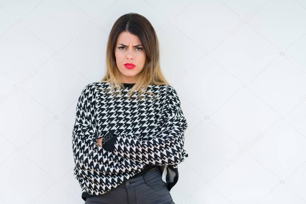 Young woman wearing casual sweater over isolated background skeptic and nervous, disapproving expression on face with crossed arms. Negative person.