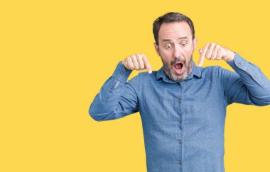 Yakışıklı orta yaş zarif komuta sizde izole üzerinde arka plan işaretleme aşağı reklam, sürpriz yüz ve açık ağız gösterilen parmakları ile