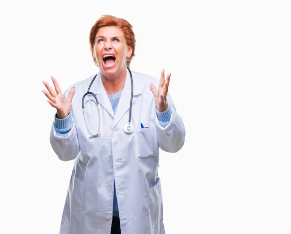 高级白种人医生妇女穿着医疗制服在孤立的背景疯狂和疯狂的喊话和大喊大叫与积极的表情和手臂抬起来 挫折的概念 — 图库照片