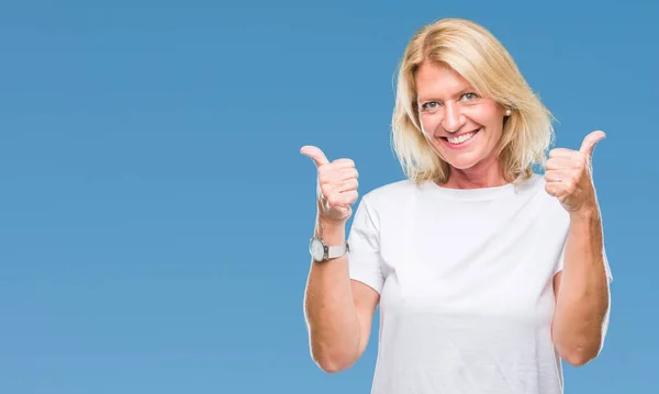 Middle age blonde woman over isolated background success sign doing positive gesture with hand, thumbs up smiling and happy. Looking at the camera with cheerful expression, winner gesture.