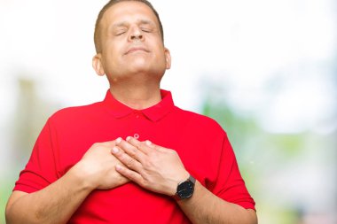 Orta yaş Arap adam ile gülümseyen izole arka plan üzerinde kapalı gözler ve yüzünde minnettar jest ile göğüs üzerinde eller. Sağlık kavramı.