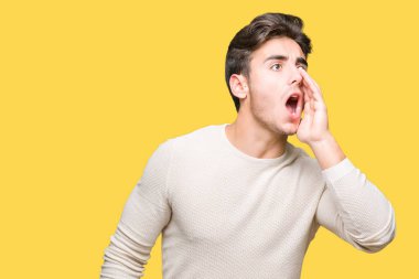 Yakışıklı delikanlı bağırarak ve ağzı üzerinde el ile yan için çığlık izole arka plan üzerinde. İletişim kavramı.