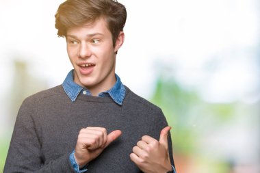 Genç yakışıklı zarif adam izole arka plan üzerinde emin gülümseyen arkasından el ve kadar başparmak ile işaret