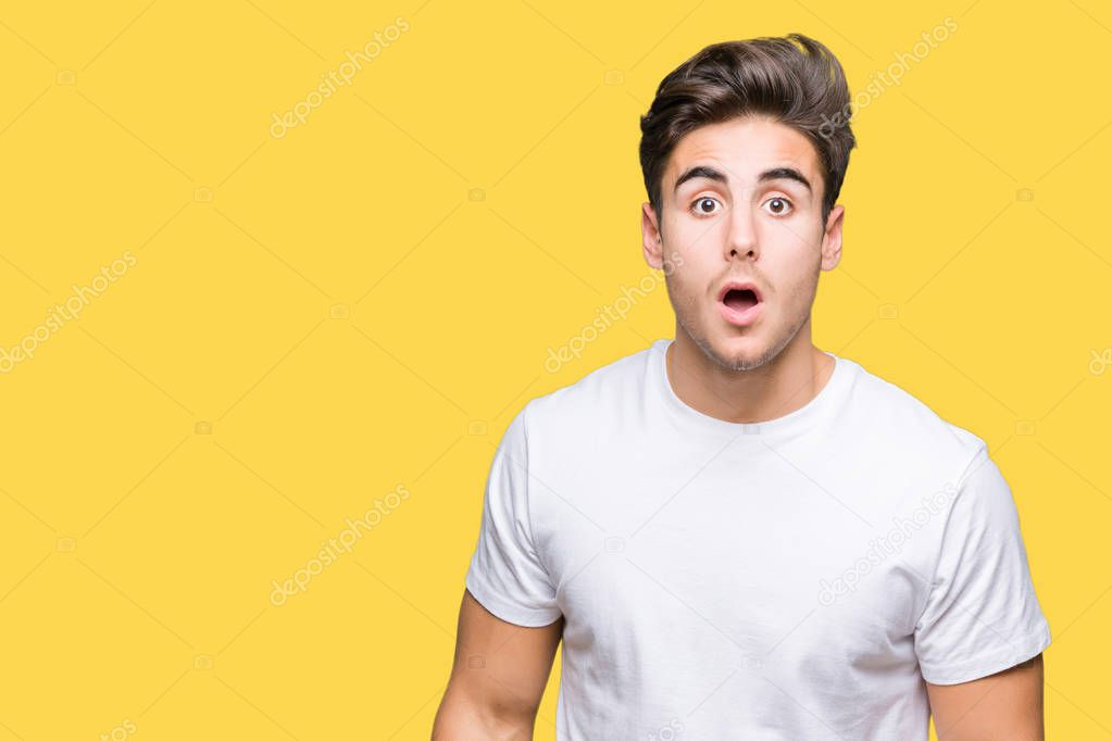 Young handsome man wearing white t-shirt over isolated background afraid and shocked with surprise expression, fear and excited face.