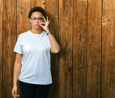 Güzel genç Afro-Amerikan kadın üzerinde gözlük takan arka plan ağız izole ve parmak ile ZIP olarak Dudaklarını kapa. Gizli ve sessiz, tabu söz