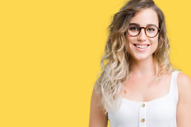Yüzünde mutlu ve güzel bir gülümseme ile izole arka plan üzerinde gözlük güzel sarışın genç kadın. Şanslı kişi.