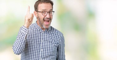 Başarılı fikirle izole arka plan işaret parmağı üzerinde gözlük takan yakışıklı orta yaş zarif üst düzey iş adamı. Çıktıktan ve mutlu. Bir numara.