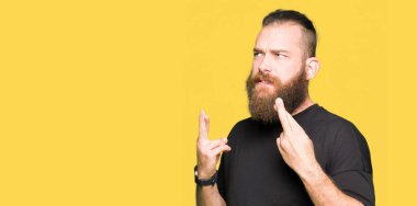 Sarışın genç gülümseyen geçiş parmakları umut ve gözleri kapalı giyiyor rahat t-shirt adam. Şans ve batıl kavramı.