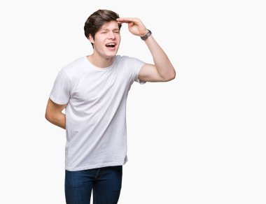 Üzerinde rahat beyaz t-shirt giyen genç yakışıklı adam arka plan çok mutlu ve gülümseyen uzakta el ile üzerine kafa seyir izole. Arama kavramı.
