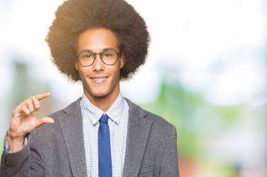 Gülümseyen bardakları ve süre seyir ve kamera boyutu işaret parmaklarıyla yapıyor el ile kendine güvenen el hareketi afro saçlı genç Afro-Amerikalı iş adamı. Ölçü kavramı.