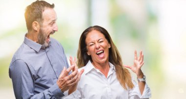 İzole arka plan kutlama üzerinde orta yaş İspanyol iş çift kızgın ve silah ile başarı için deli kaldırdı ve heyecanlı çığlık gözler kapalı. Kazanan kavramı