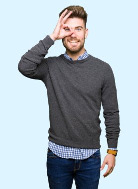 Genç yakışıklı zarif adam gülümsüyor, parmakları ile mutlu yüz üzerinden seyir göz el ile ok jest yapıyor.