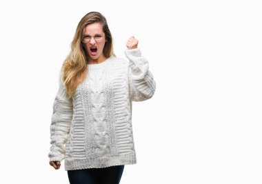 Kış kazak ve güneş gözlüğü üzerinde giyen genç güzel sarışın kadın arka plan kızgın izole ve kızgın yetiştirme hayal kırıklığı ve öfke ile bağırarak süre öfkeli yumruk. Öfke ve agresif kavramı.