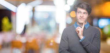 Çene düşünme hakkında soru, dalgın ifade üzerine el ile izole arka plan üzerinde genç yakışıklı zarif adam. Düşünceli yüzüyle gülümsüyor. Şüphe kavramı.