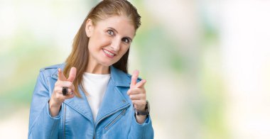 Fotoğraf makinesi ile mutlu ve komik yüz için parmakları işaret izole arka plan üzerinde moda deri ceket giyen güzel orta yaş Olgun kadın. İyi enerji ve vibes.