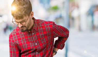 Genç yakışıklı adam gözlük izole üzerinde el ile geri, kas ağrısı dokunmadan acı sırt ağrısı, arka plan