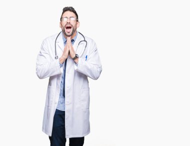 Yakışıklı genç doktor adam yalvarıyor ve umut ifade yüzünde çok duygusal ve endişe ile birlikte elleriyle dua izole arka plan üzerinde. Bağışlanmak. Din kavramı.