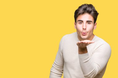 Yakışıklı delikanlı bir öpücük el ile güzel ve seksi olmak hava üfleme kamera bakarak izole arka plan üzerinde. Aşk ifade.