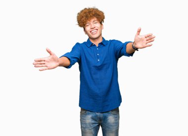 Sarılmak için Kollarını açarak gülümseyerek kameraya bakarak afro saçlı genç yakışıklı zarif adam. Neşeli ifade kucaklayan mutluluk.