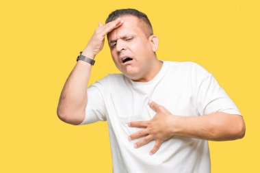 Orta yaş Arap adam wearig beyaz t-shirt izole arka plan dokunmadan üzerinde hastalık ve ateş, grip ve soğuk, virüs hasta için alın