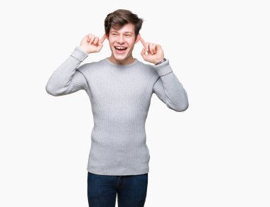 Üzerinde kış kazak giyen genç yakışıklı adam arka plan gülen çekerek kulakları parmaklar, komik jest ile izole. Seçmelere sorun