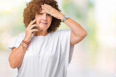 Orta ager üst düzey kadın elle kafasına, utanç ve sürpriz yüz ile şok vurguladı izole arka plan üzerinde Smartphone'da söz öfkeli ve sinirli. Korku ve hata için üzgün.