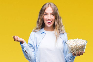 Duygu tezahürat gurur çığlık ve zafer ve başarı çok heyecanlı, kutluyor izole arka plan üzerinde patlamış mısır yemek güzel sarışın genç kadın