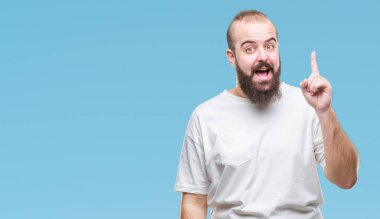 Başarılı fikirle izole arka plan üzerinde işaret parmağı rahat t-shirt giyen genç beyaz hipster adam. Çıktıktan ve mutlu. Bir numara.