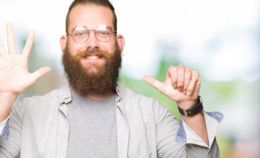 Gösterilen ve parmak altıncı ile gülümseyen ise kendinden emin ve mutlu yukarıyı gözlüklü genç sarışın adam.