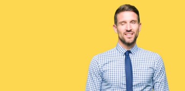 Kravat seksi bir ifadeyle, neşeli ve mutlu yüzünü kameraya bakarak göz kırpıyor giymiş yakışıklı iş adamı.