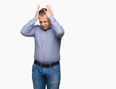 Orta yaş Arap iş adamı çünkü umutsuz ve stresli baş ağrısı acı izole arka plan üzerinde ağrı ve migren. Ellerini kafasına.