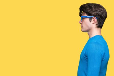 İzole arka tarafına, seyir üzerinde mavi gözlük takan genç yakışıklı adam sakin ol kendine güvenen gülümseme ile doğal yüz pozuyla profili.