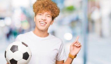 Futbol futbol topu çok mutlu el ve parmak ile tarafına işaret tutan genç yakışıklı adam