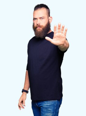 Genç sarışın adam rahat t-shirt giyen elin avuç ile şarkı stop yapıyor. Negatif ve ciddi bir jest yüz ifadesiyle uyarı.