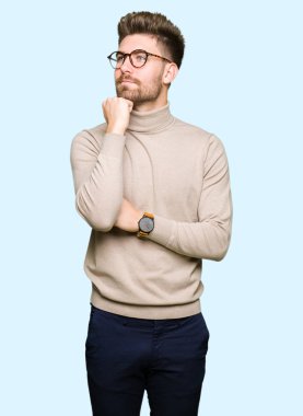 Gözlüklü el ile çene düşünme hakkında soru, dalgın ifade üzerine genç yakışıklı iş adamı. Düşünceli yüzüyle gülümsüyor. Şüphe kavramı.