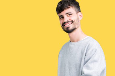 Açık el ile doğal gülümseyen girmek için davet izole arka plan üzerinde sweatshirt giyen genç yakışıklı adam