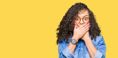 Genç güzel kadın kıvırcık saçlı gözlüklü ağız hata için elleriyle kapsayan şok. Gizli kavramı.