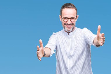 Sarılmak için kollarını açarak gülümseyerek kameraya bakarak izole arka plan üzerinde gözlük takan orta yaş ağarmış komuta sizde. Neşeli ifade kucaklayan mutluluk.