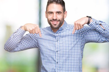 Yüzünde gülümseme ile kendinden emin görünüyorsun, kendini gururlu ve mutlu parmakları ile işaret izole arka plan üzerinde genç yakışıklı adam.