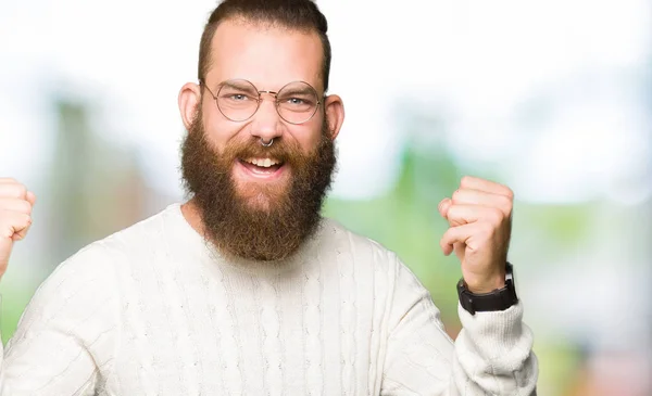 Joven Hombre Hipster Con Gafas Suéter Invierno Celebrando Sorprendido Sorprendido —  Fotos de Stock