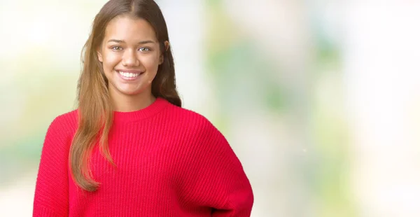 顔に幸せでクールな笑顔で孤立した背景の上に赤い冬のセーターを着て若い美しいブルネット女性 幸運な人 — ストック写真
