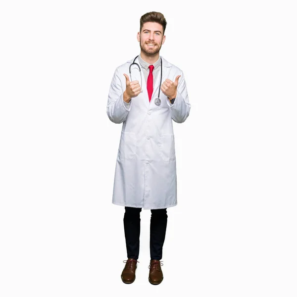 Νεαρός Γιατρός Όμορφος Άνθρωπος Φορώντας Ιατρική Παλτό Σημάδι Επιτυχίας Κάνει — Φωτογραφία Αρχείου