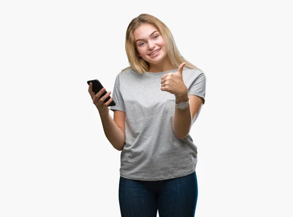 若い白人女性笑顔の サイン 優秀な兆候を親指をやって幸せな孤立の背景にスマート フォンを使用してメッセージを送信します — ストック写真