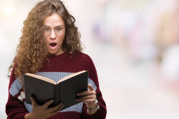 Young Brunette Girl Reading Book Wearing Glasses Isolated Background Scared — Stock Photo, Image