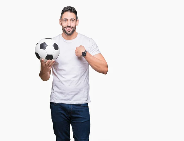 Молодой Человек Держит Футбольный Мяч Изолированном Фоне Неожиданным Лицом Указывающим — стоковое фото