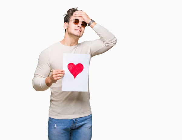 Joven Hombre Guapo Sosteniendo Tarjeta Con Corazón Rojo Sobre Fondo — Foto de Stock